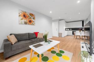 a living room with a couch and a table at Manchester Haven Chique Modern Apartment in Manchester