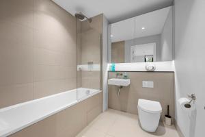 a bathroom with a tub and a toilet and a sink at Manchester Haven Chique Modern Apartment in Manchester +13 photos