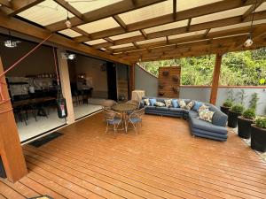 a patio with a couch and a table on a deck at Tanuri in Itapoa