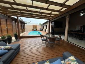 a patio with a table and chairs and a pool at Tanuri in Itapoa +8 photos