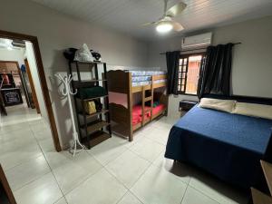 a bedroom with a bed and a room with a window at Tanuri in Itapoa