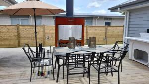 a table and chairs with an umbrella on a patio at Mermaid Waterways in Whitianga
