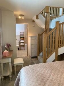 ein Schlafzimmer mit einer Treppe und einem Bett mit einem Schreibtisch in der Unterkunft Bakers Cottage in Ironbridge