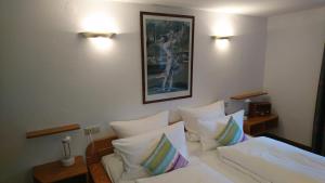 a bedroom with a bed with white sheets and pillows at Pension Landhaus Fischer in Maßweiler +12 photos