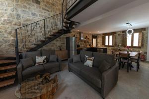 a living room with two couches and a staircase at CR Las Espiñuelas in Poveda de la Sierra