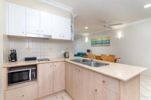 道格拉斯港Seascape Holidays at Heritage Resort的带白色橱柜和水槽的厨房