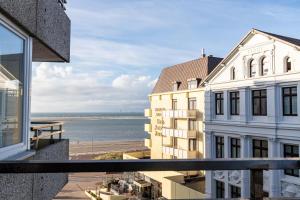 a balcony with a view of the beach and buildings at Sandbank Domizil Borkum in Borkum