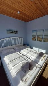 a large white bed in a bedroom with a wooden ceiling at Haus Sieberns Haus Sieberns in Norderney