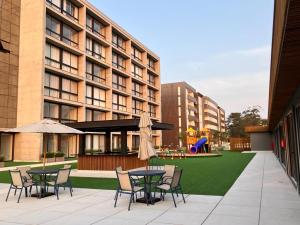 a patio with tables and chairs and a playground at Loft Livin Resort 411 T3 Piscina Térmica Atlantida Xangri-la in Xangri-lá