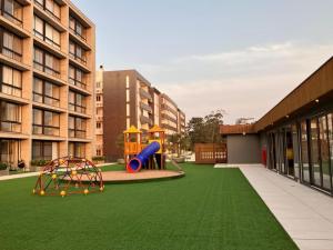 a playground with a slide on a green lawn at Loft Livin Resort 411 T3 Piscina Térmica Atlantida Xangri-la in Xangri-lá
