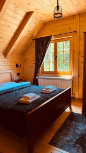 a bedroom with a bed in a wooden cabin at Planinska kuca Grujic in Kolašin