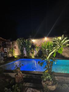 a swimming pool in a garden at night at Wisnu Lumbung Uluwatu in Uluwatu
