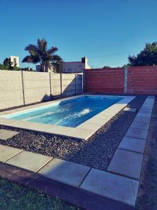 a swimming pool with rocks and a brick wall at Cabaña Las Martinetas in María Grande +9 photos
