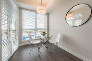 a dining room with a table and chairs and a mirror at Modern Old Town Suite With Private Balcony in Victoria