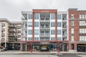 a large apartment building with a sign on it at Modern Old Town Suite With Private Balcony in Victoria