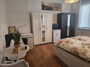 a bedroom with a bed and a table and a television at Friend House in Brussels