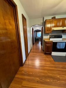 a kitchen with a wooden floor and a hallway at Comfy getaway at falls! in Niagara Falls