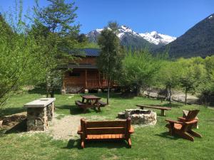 a group of picnic benches in front of a cabin at Rio Manso cabaña km 18 in Río Villegas