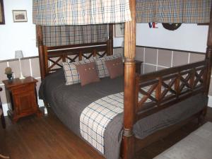 a bedroom with a bed with a wooden frame at La Mirabelle in Cornimont