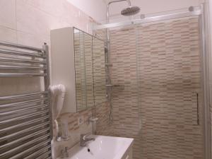 y baño con lavabo y ducha con espejo. en Trevi Elegance Suite, en Roma