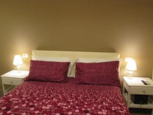 1 dormitorio con 1 cama con almohadas moradas y 2 lámparas en Trevi Elegance Suite, en Roma