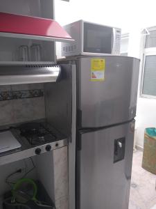 a kitchen with a refrigerator and a microwave at usoinmobiliario in Medellín