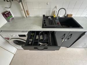 a kitchen counter with a sink and a stove at Appart Orleans Gare in Orléans