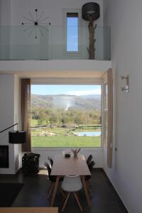 a dining room with a table and a large window at Agua Antigua Casa Rural in Gargüera