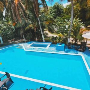 a blue swimming pool with chairs and palm trees at Hermoso Duplex campestre in Honda +19 photos