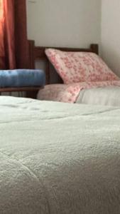 a bedroom with a white bed and a chair at Apto 27 Flamingo in Pato Branco