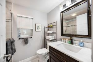 une salle de bain avec un lavabo, des toilettes et un miroir dans l'établissement Kirkland Home with 2 Queen Beds - Totem Lake Village, à Kirkland 25 autres photos