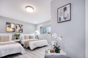 - une chambre blanche avec 2 lits et une table dans l'établissement Kirkland Home with 2 Queen Beds - Totem Lake Village, à Kirkland