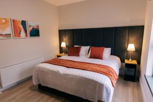 een slaapkamer met een groot bed met twee lampen bij River Walk Apartments in Derry Londonderry +4 foto's