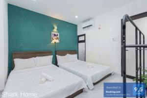 two beds sitting next to each other in a room at Shark Home Vũng Tàu 117 PCT in Vung Tau