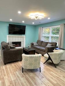 ein Wohnzimmer mit Sofa und Stühlen und einem Kamin in der Unterkunft Quantico Graduation Home Visit DC 5 bedrooms 2 King Beds Stafford in Stafford