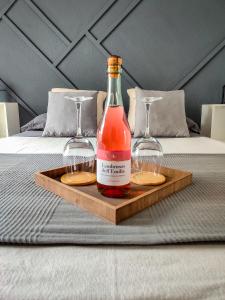 una botella y dos vasos en una bandeja en una cama en ESCAPADAS ROMÁNTICAS Gavira Apartamento, en Rota