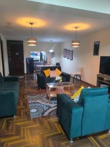 un soggiorno con due divani e una TV di Kusi Wasi a Cuzco