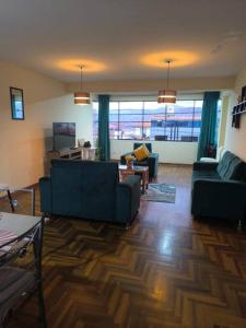 un soggiorno con due divani blu e una grande finestra di Kusi Wasi a Cuzco