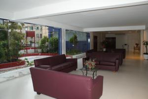 a living room with couches and tables and large windows at Flat Sirena - São Vicente in São Vicente +30 photos