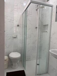 um banheiro com chuveiro, vaso sanitário e pia em Kit Jd Guilhermina na Praia Grande mais 26 fotografias