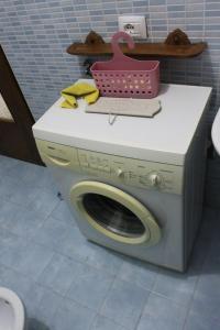 a washing machine with a pink basket on top of it at MAISON 30 in Induno Olona
