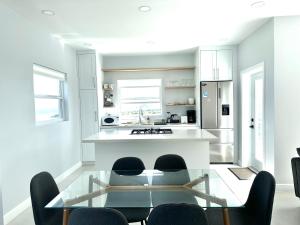 a kitchen with a glass table and some chairs at The Luxury Escape in Rouarné
