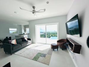 a living room with a couch and a tv at The Luxury Escape in Rouarné
