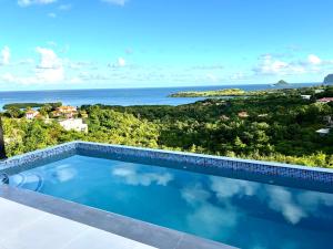 a swimming pool with a view of the ocean at The Luxury Escape in Rouarné