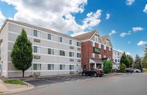 an apartment building with a car parked in a parking lot at Extended Stay America Suites - Cincinnati - Blue Ash - Reed Hartman in Blue Ash