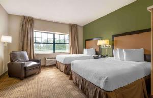 a hotel room with two beds and a chair at Extended Stay America Suites - Chicago - Burr Ridge in Burr Ridge