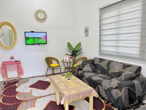 a living room with a couch and a table at Homestay Keboon Rantau Panjang in Rantau Panjang