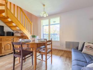 une salle à manger avec une table et un canapé bleu dans l'établissement Duplex 6 pers avec balcon et parking à Bourisp - FR-1-296-507, à Bourisp 7 autres photos