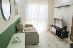 ein Wohnzimmer mit Sofa und Fernseher in der Unterkunft Espaço entre Pizza & Café in Pindamonhangaba