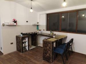 a kitchen with a counter and a table and chairs at Cori Wasi in Cusco
